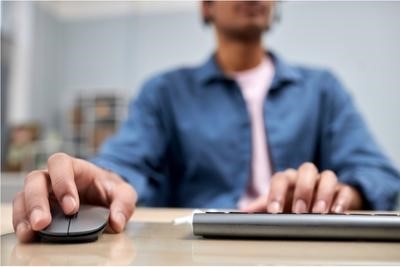 Closeup of male hands typing and using mouse